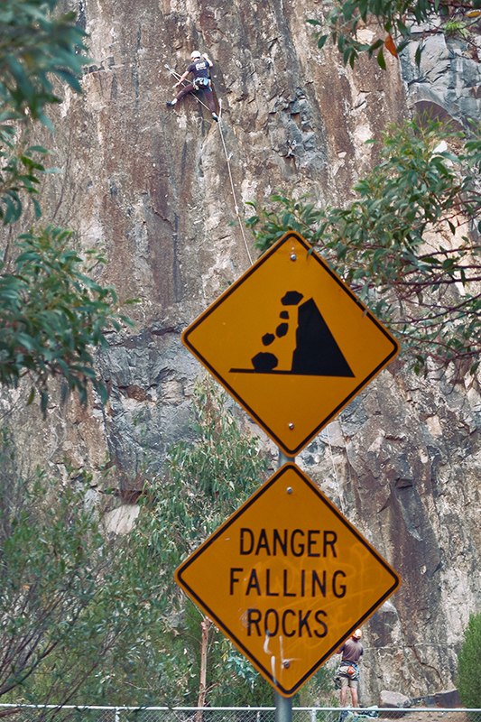 A climber pays no heed to the warning signs at the cliffs near the start of Waterworks Road.