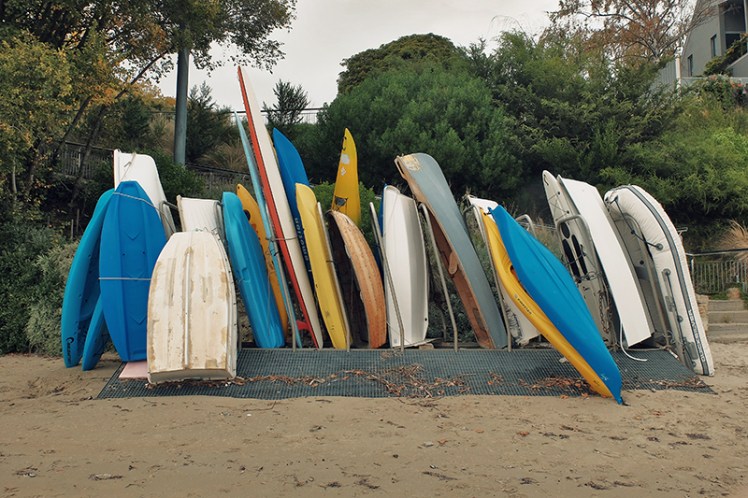 Row row row your boat. A collection of kayaks, canoes and row boats sits in storage.